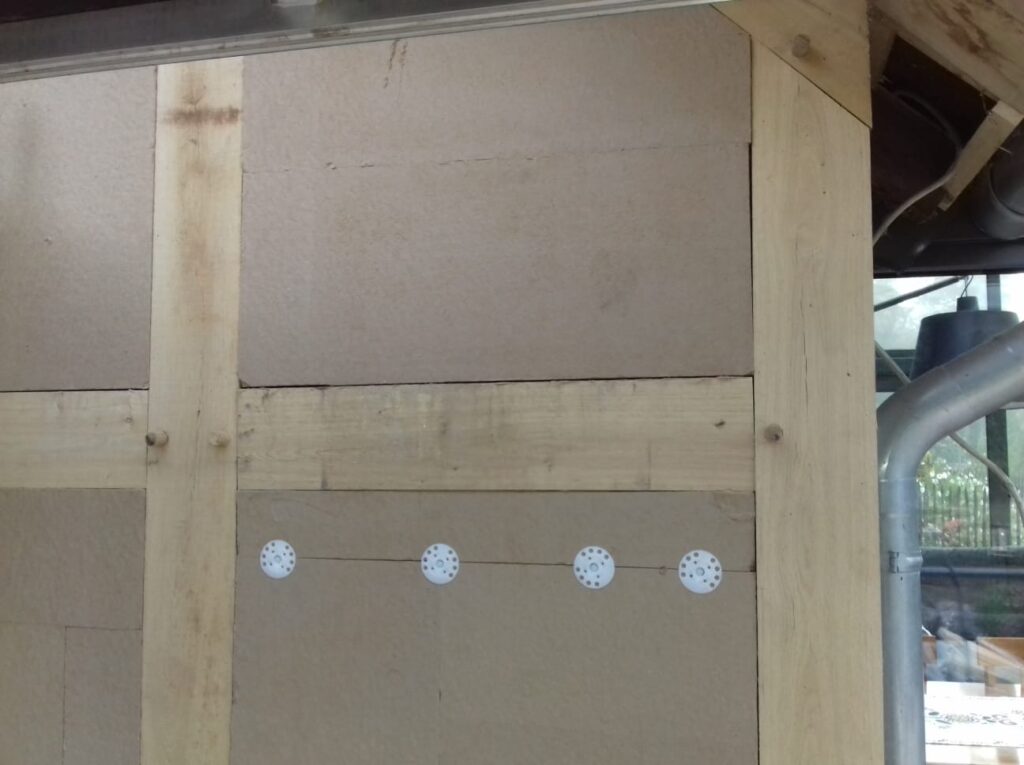 Erstellung einer Fachwerkfassade vor dem Giebel aus Massivmauerwerk